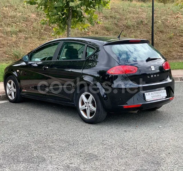 Un coche negro está estacionado al costado de la carretera.