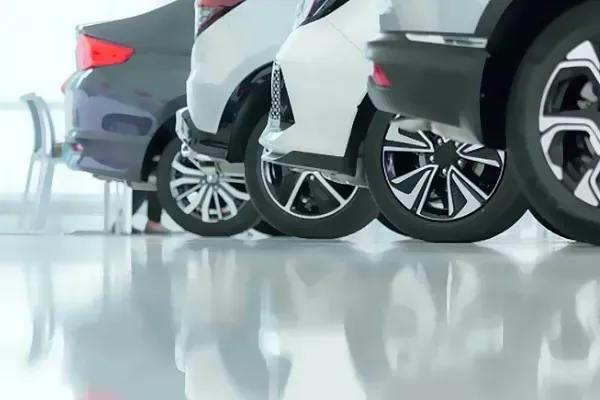 Una fila de coches están aparcados uno al lado del otro en una sala de exposición.