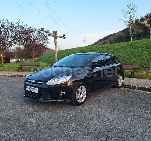 Un Ford Focus negro está estacionado en un estacionamiento.