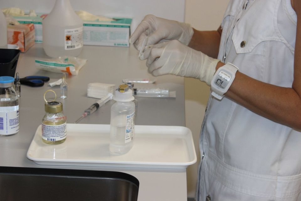 Une infirmière portant une montre prépare une injection