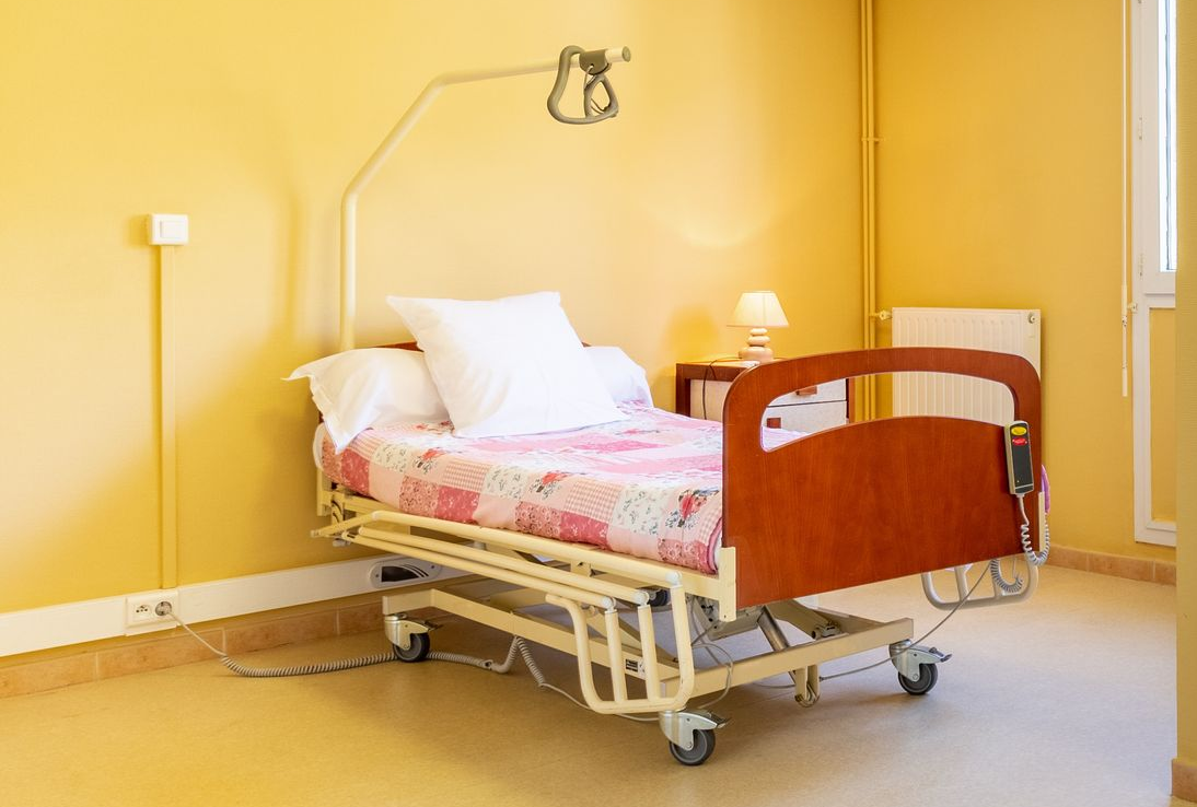 Un lit médicalisé dans une chambre jaune