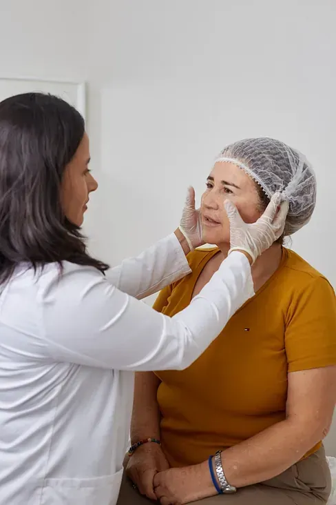 Una mujer se está haciendo examinar el rostro por un médico.