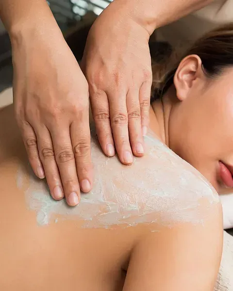 Una mujer está recibiendo un masaje en la espalda en un spa.