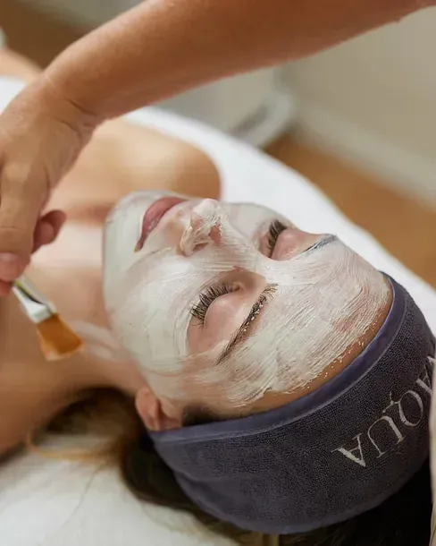Una mujer está recibiendo un tratamiento facial en un spa.