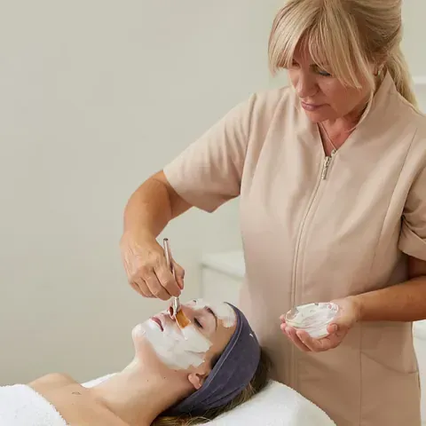 Una mujer está recibiendo un tratamiento facial en un spa.