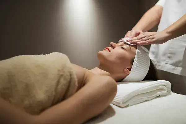 Una mujer está recibiendo un tratamiento facial en un spa.
