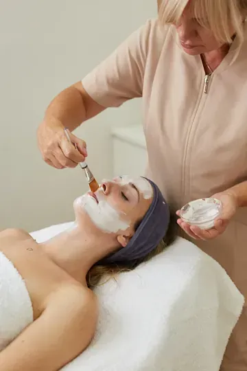 Una mujer está recibiendo un tratamiento facial en un spa.