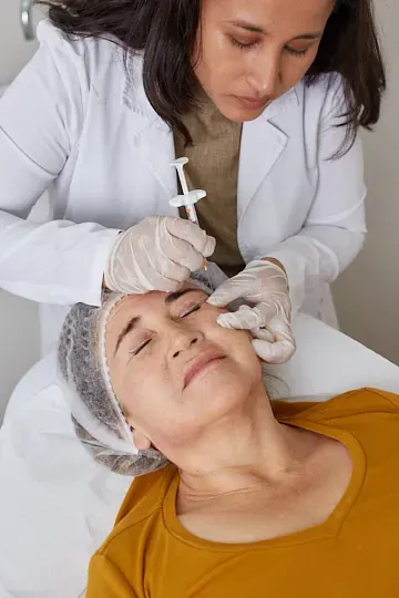 Una mujer recibe una inyección de botox en la cara.