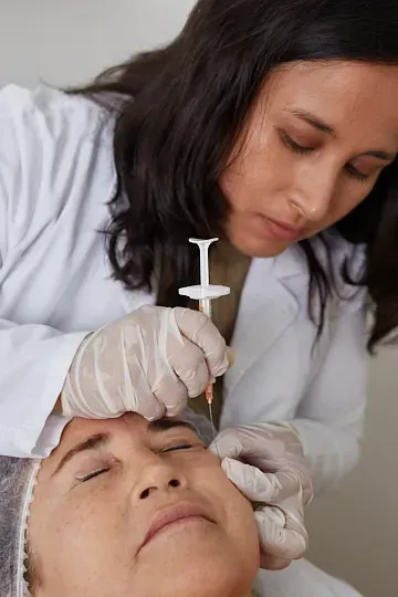 Una mujer recibe una inyección de botox en la cara.