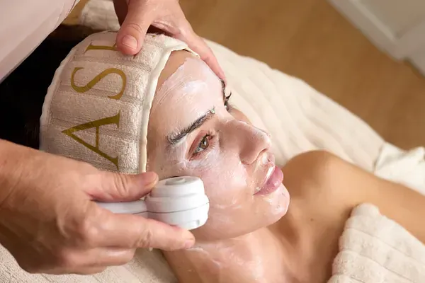 Una mujer está recibiendo un tratamiento facial en un spa.