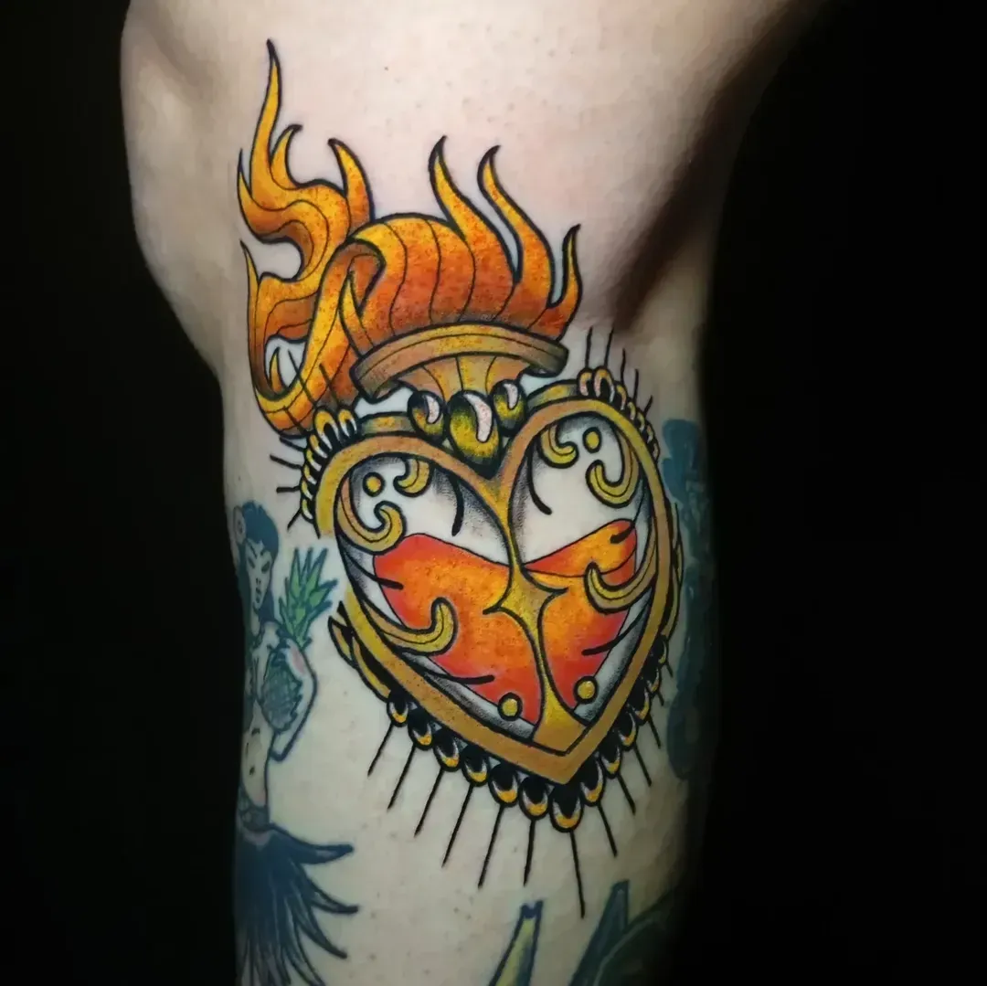 Tatuaje de un frasco en forma de corazón con una llama en la parte superior, con llamas anaranjadas y líquido, en un brazo.