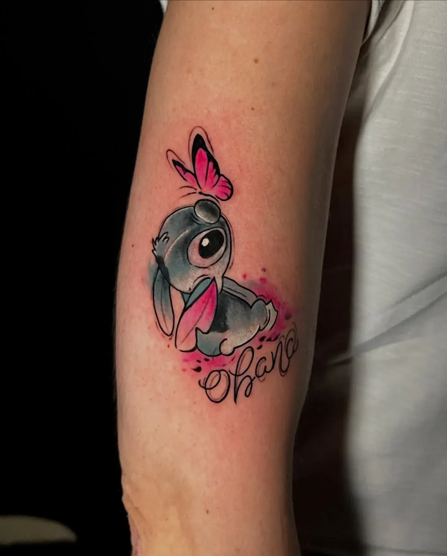 Tatuaje de conejo de dibujos animados con mariposa rosa; escritura 