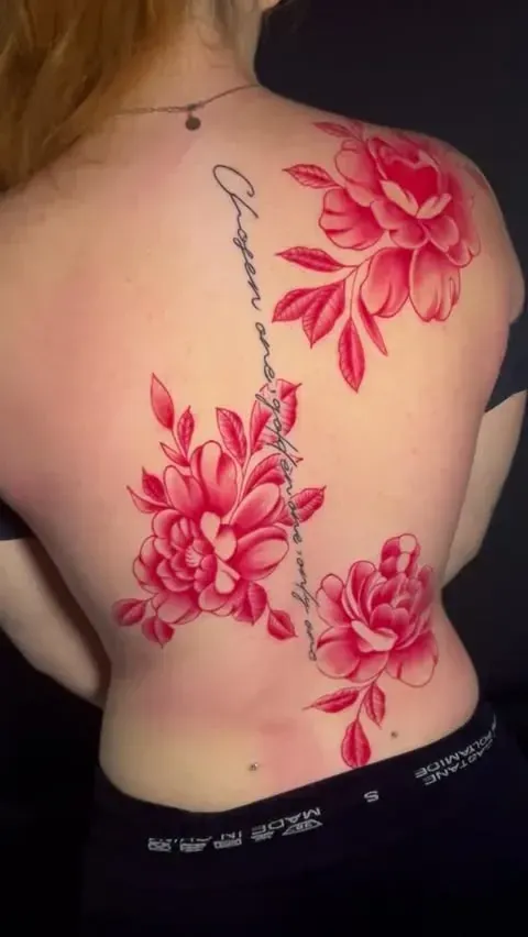 Parte posterior con tatuaje floral rojo y escritura a lo largo del lomo.