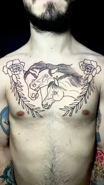 Tatuaje en el pecho de un hombre que presenta tres cabezas de caballos rodeadas de follaje y dos flores.
