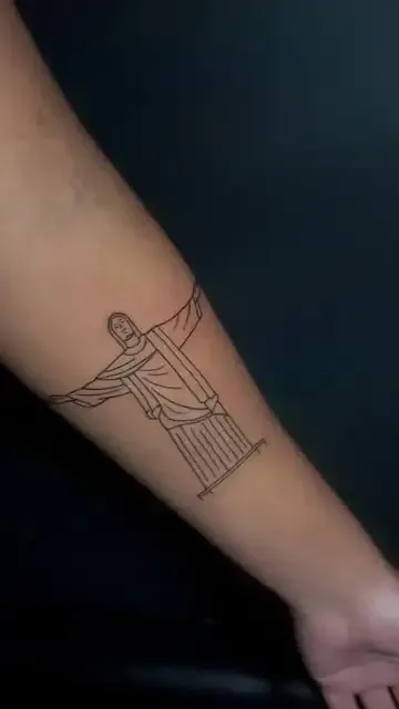 Tatuaje de arte lineal de la estatua del Cristo Redentor en un brazo.