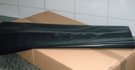 Painel preto da porta do carro apoiado em uma caixa de papelão.