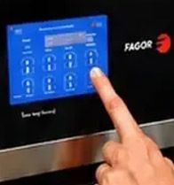 Un dedo pulsando el panel de control táctil azul de un electrodoméstico Fagor.