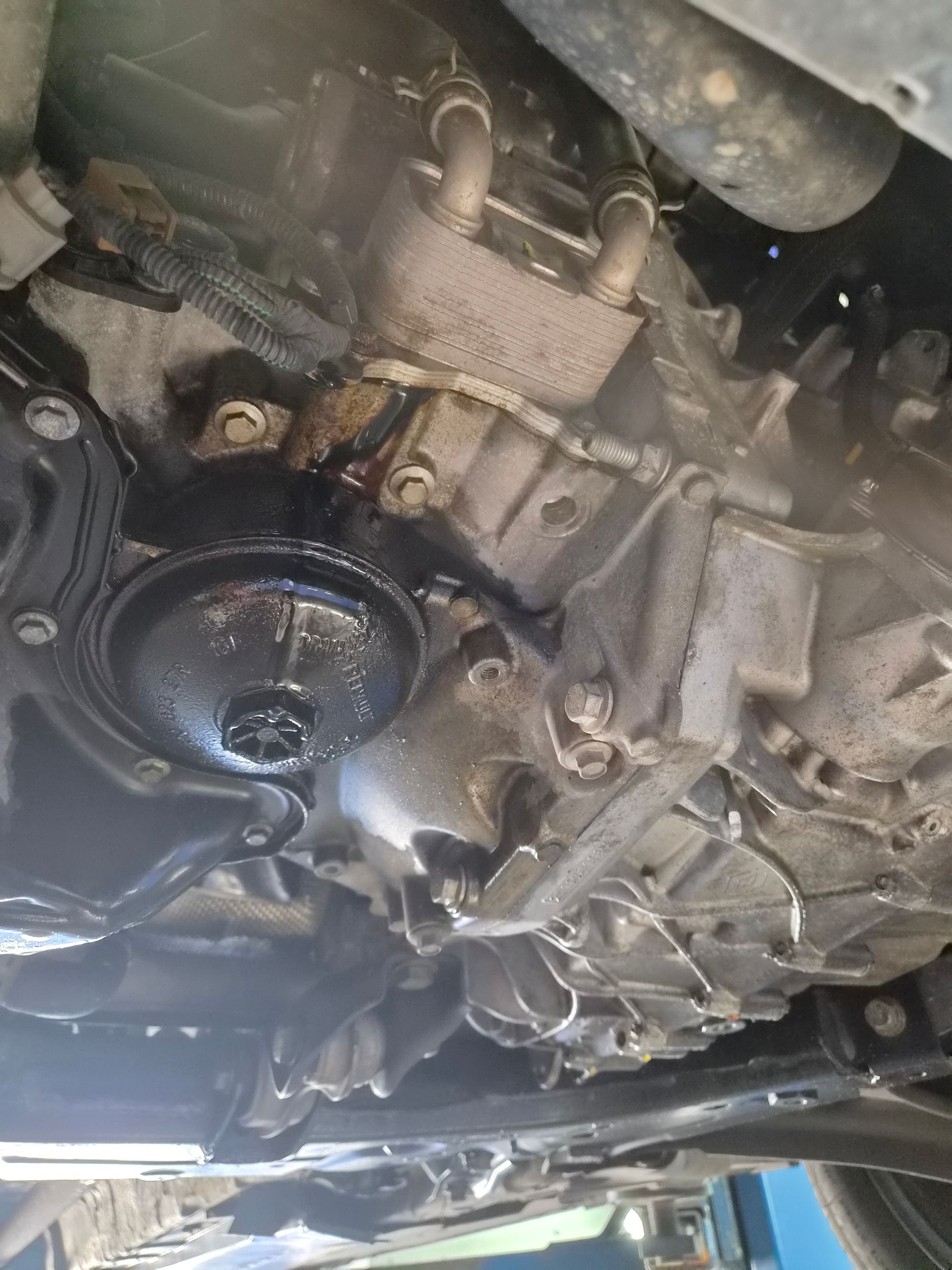 Dessous d’une voiture avec une fuite d’huile autour du moteur et de la transmission