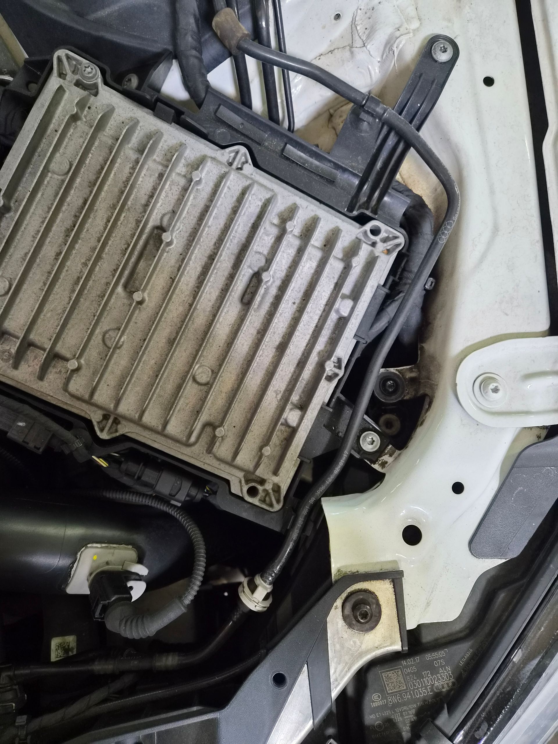 Module électronique automobile en métal installé dans le compartiment moteur d’une voiture.