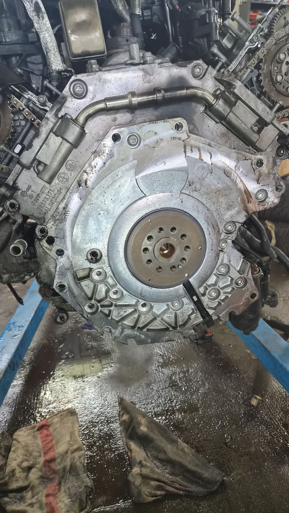Gros plan sur une imposante machine industrielle ou un moteur doté d’un couvercle métallique circulaire, couvert de crasse et de débris.