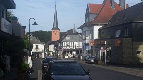 Ein Auto steht am Straßenrand vor einer Kirche