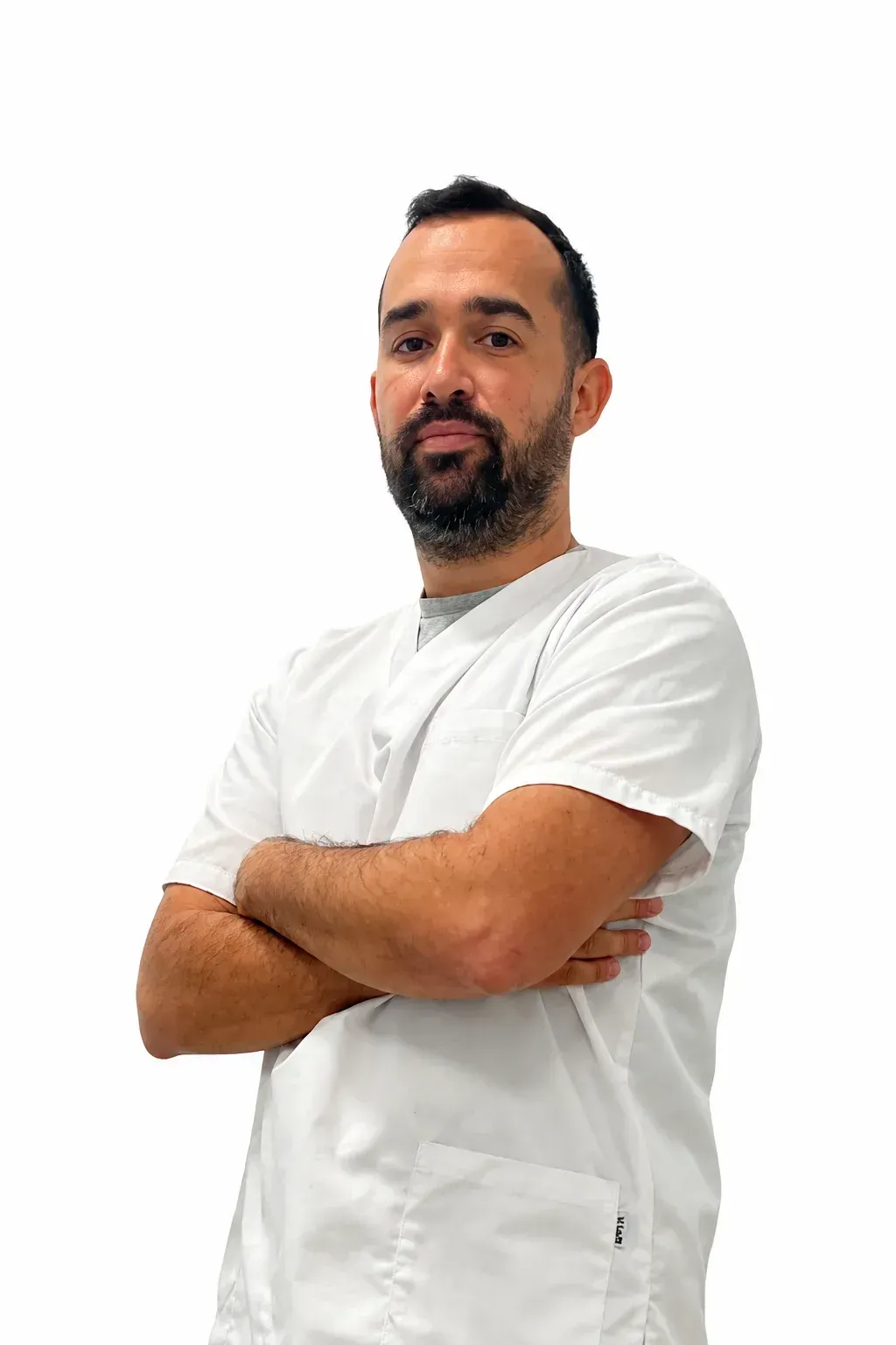 Persona con camisa blanca y brazos cruzados, de pie sobre un fondo blanco liso.