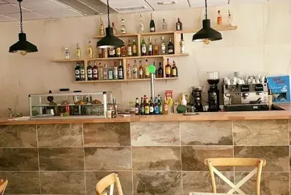 Un restaurante con un bar y muchas botellas en los estantes.