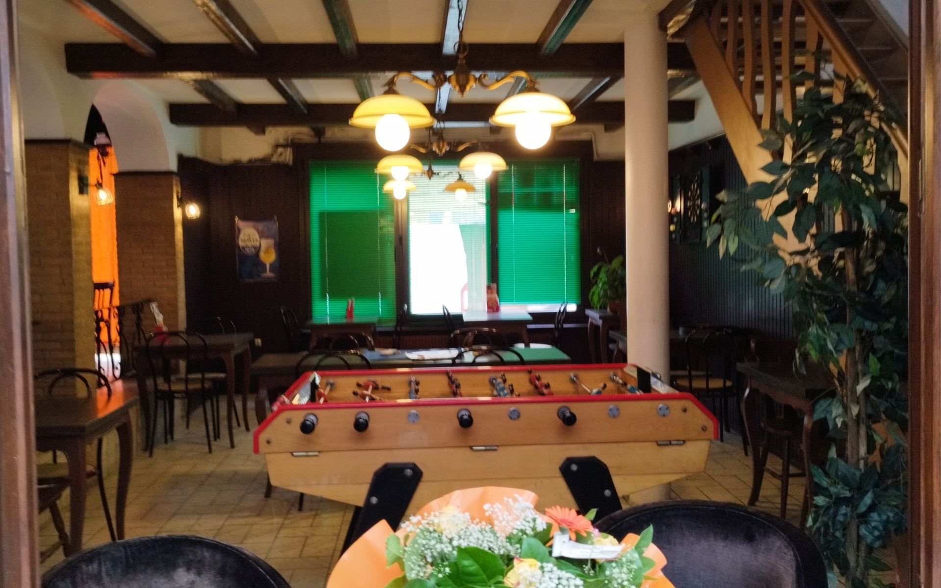 Salle de jeux confortable de style chalet avec table de billard, fenêtre rétroéclairée et lampes globe suspendues.