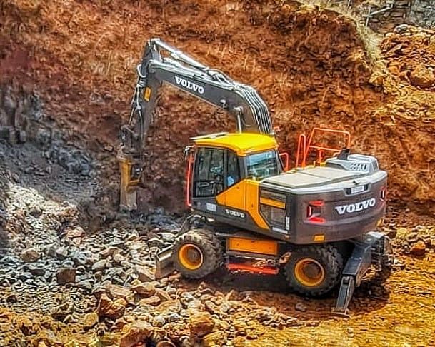 Una excavadora Volvo está cavando un hoyo en la tierra.