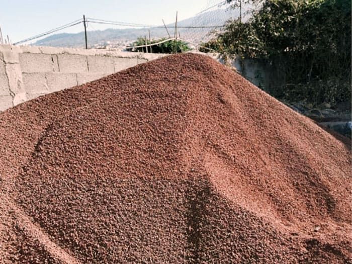 Un montón de tierra está delante de una pared de ladrillos.