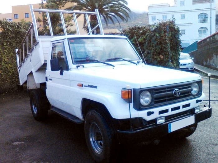 Una camioneta Toyota blanca está estacionada en un estacionamiento.