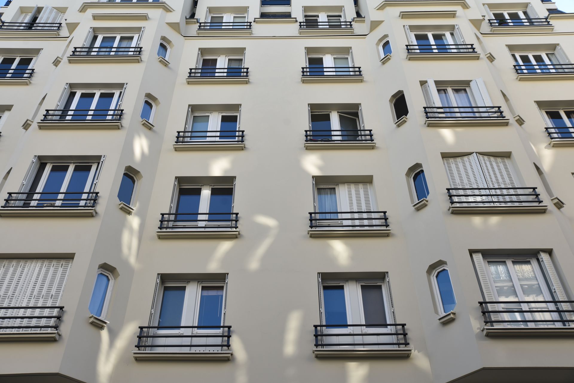 Façade d'un immeuble d'appartements beige, vue d'en bas
