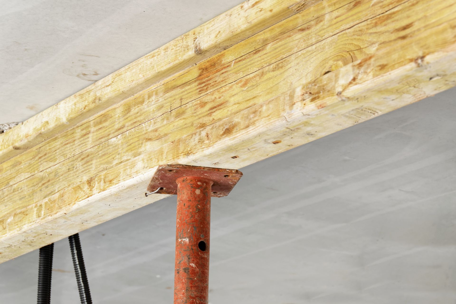 Poteau de support sous une poutre en bois.