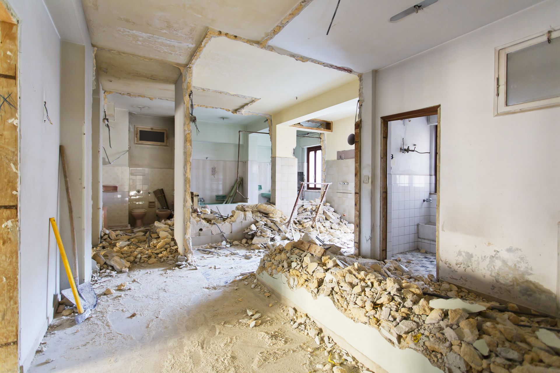 Intérieur avec des gravats, des murs cassés et des débris apparents au sol