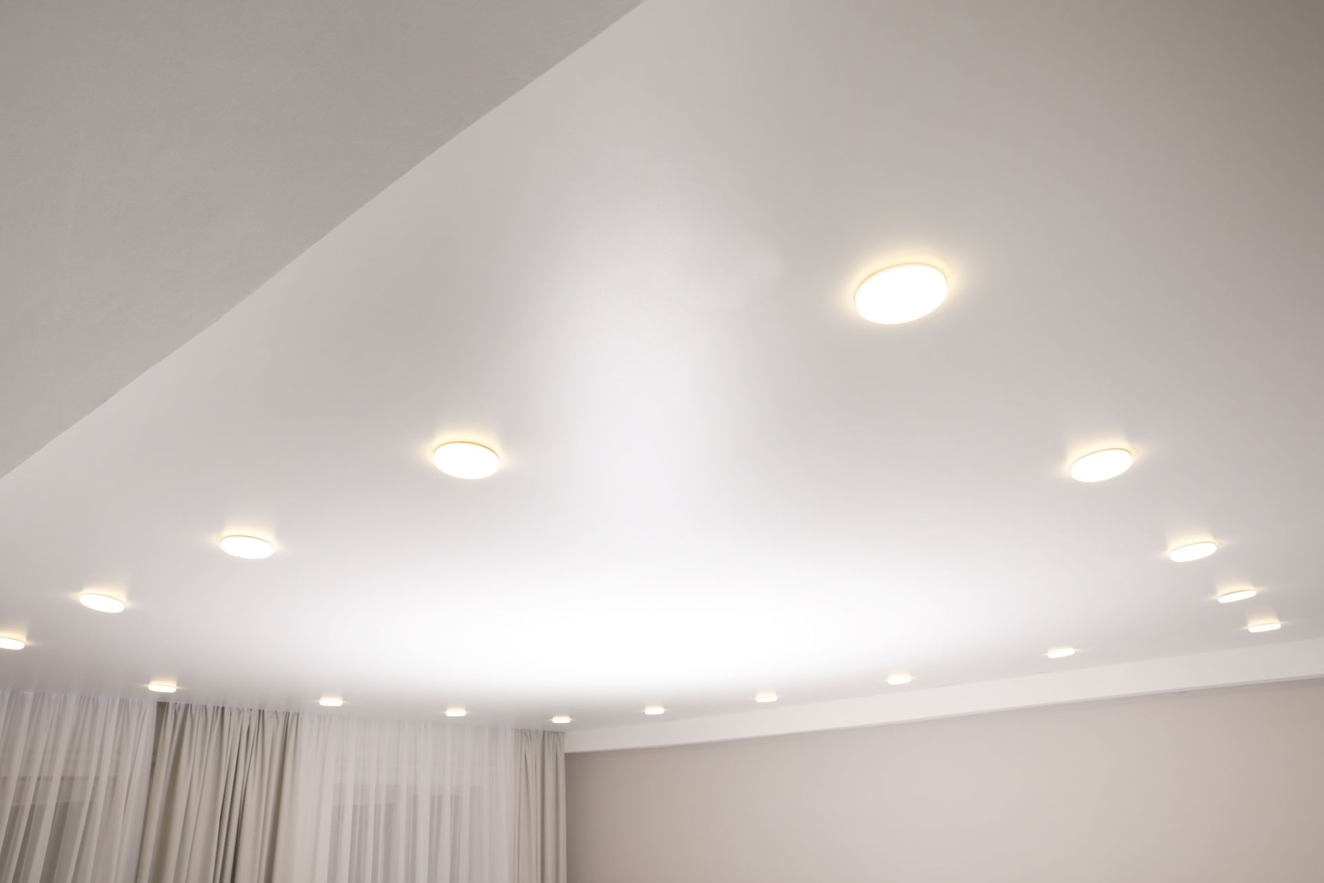 Plafond blanc avec de nombreux spots encastrés dans une pièce moderne