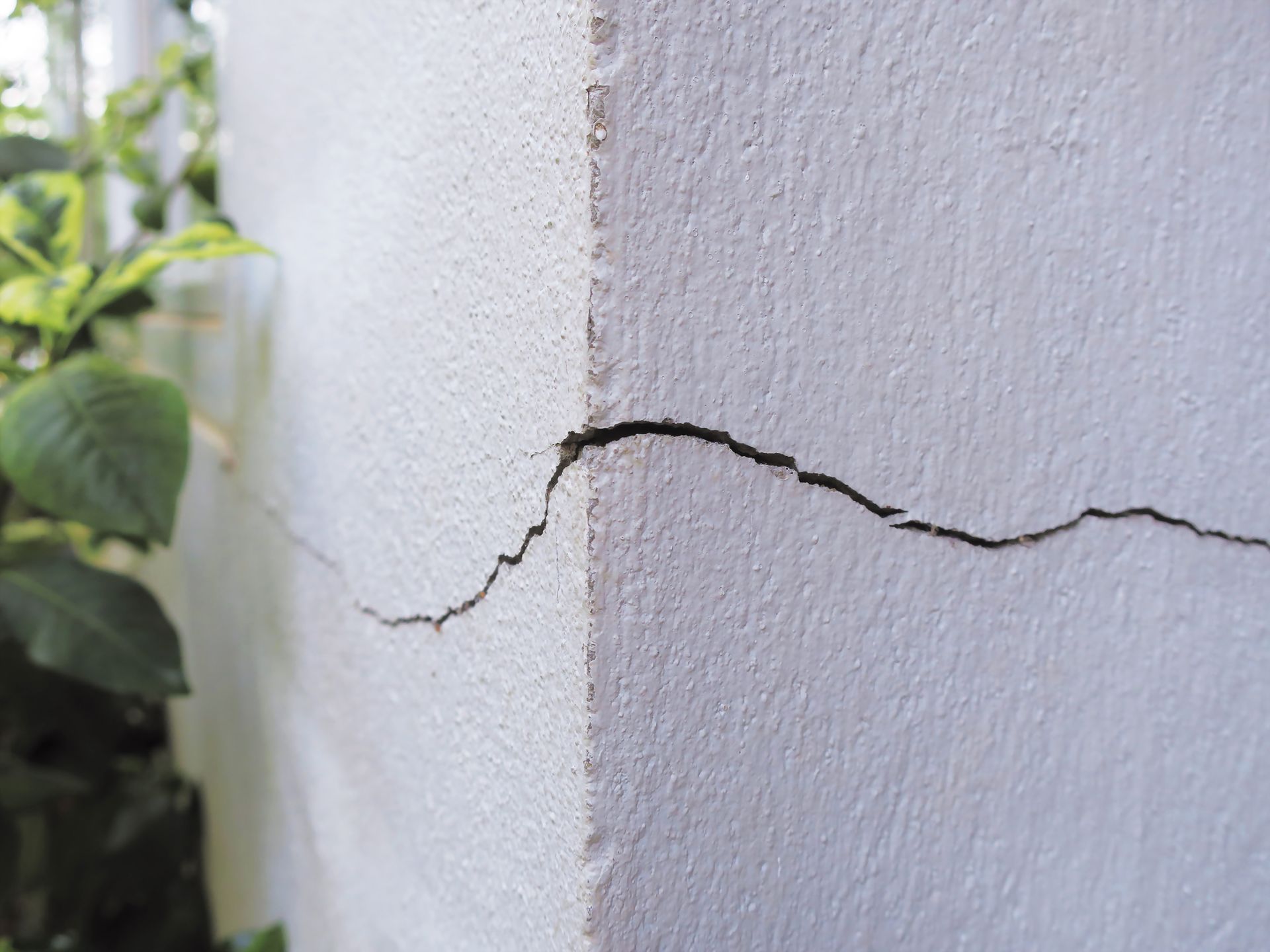 Fissure traversant un mur extérieur blanc