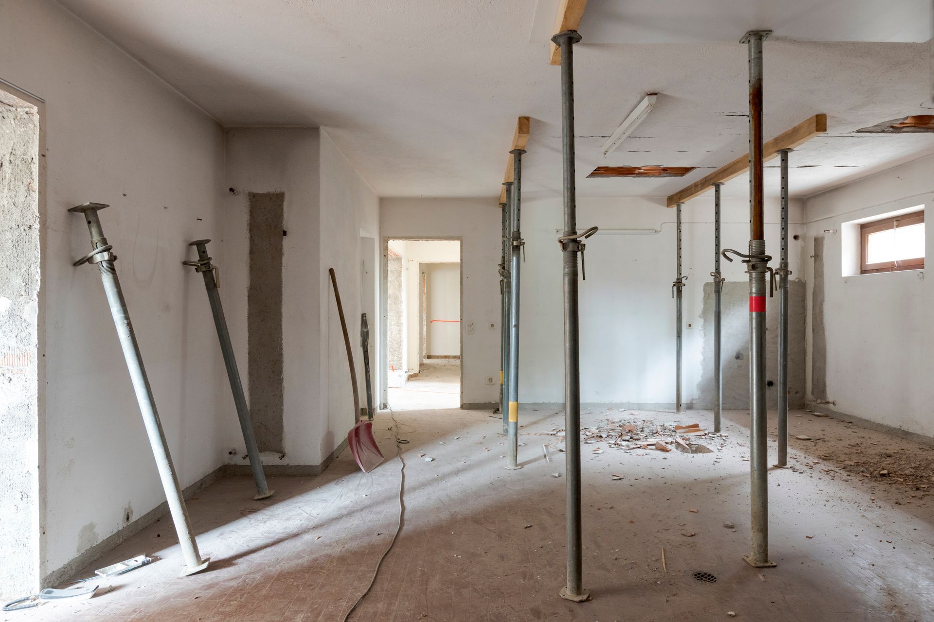 Pièce intérieure inachevée avec poteaux de soutien et débris de construction au sol