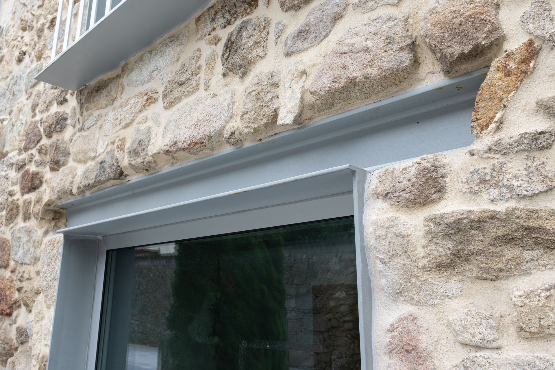 Une fenêtre à encadrement gris avec une poutre IPN