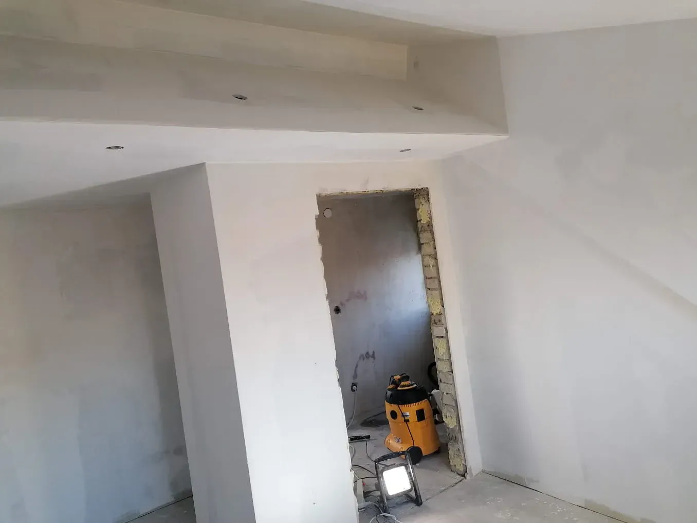 Mitten im raum steht ein staubsauger.