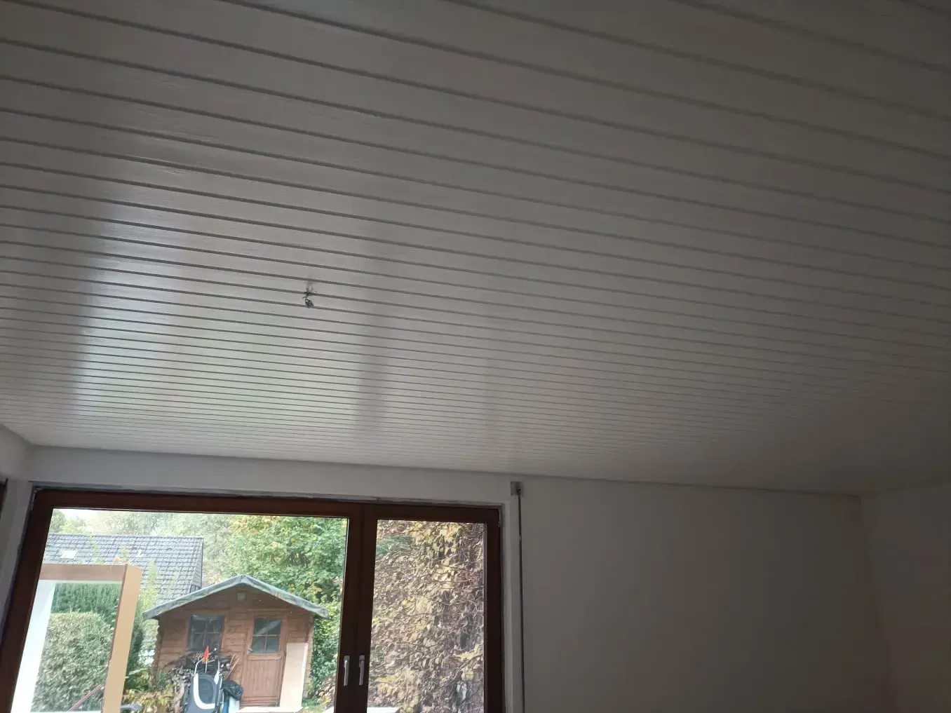 Ein Raum mit einem Fenster und einer weißen Decke