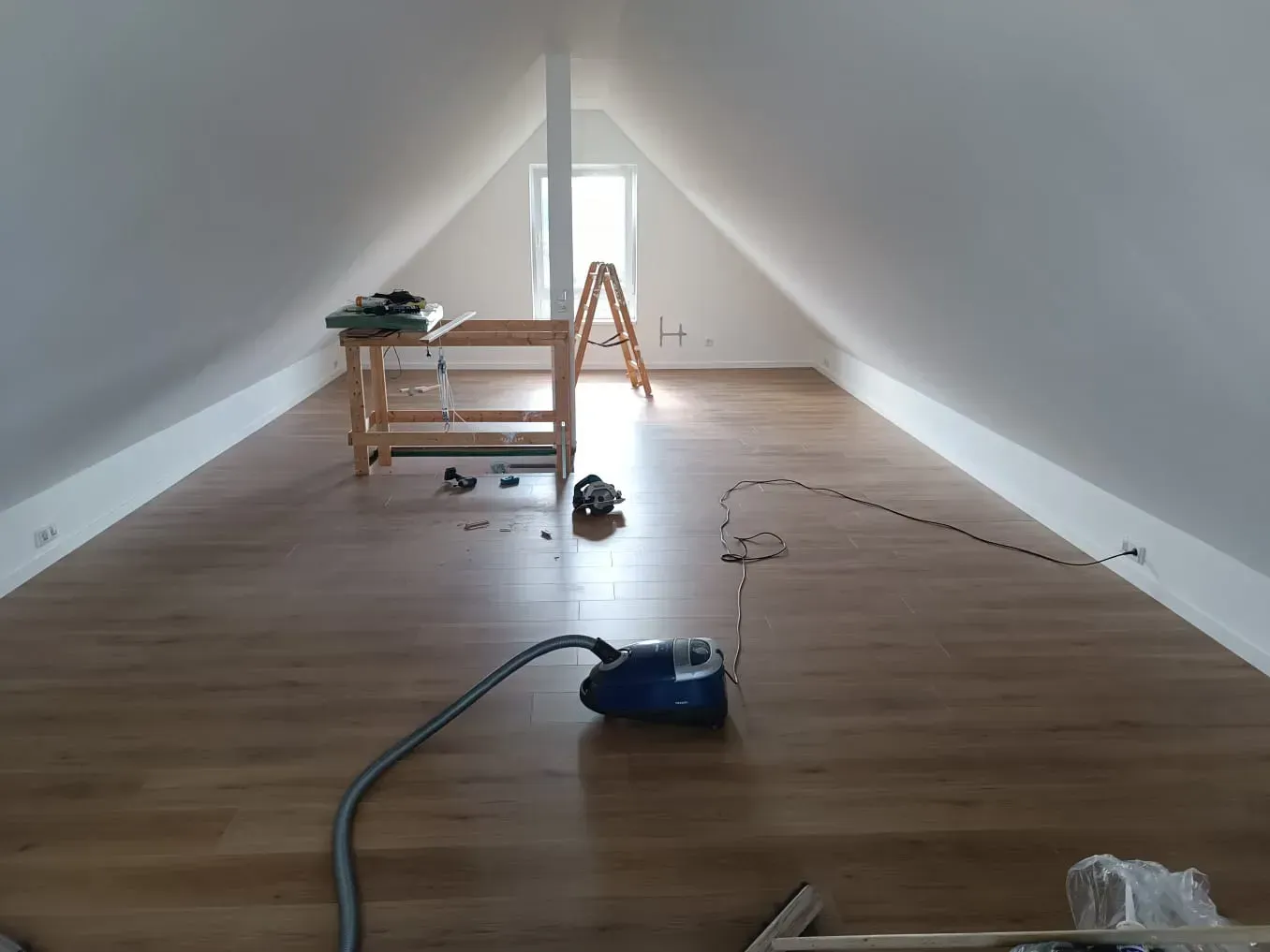 Ein Dachboden mit einem Staubsauger auf dem Boden