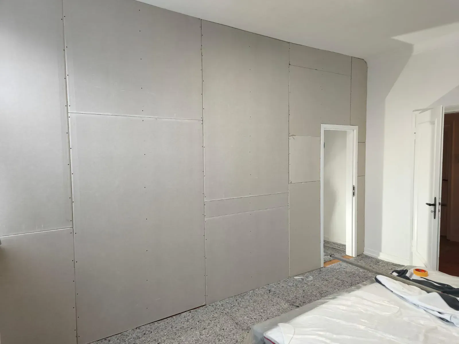 Ein Schlafzimmer mit einer großen Wand und einer Tür im Bau.