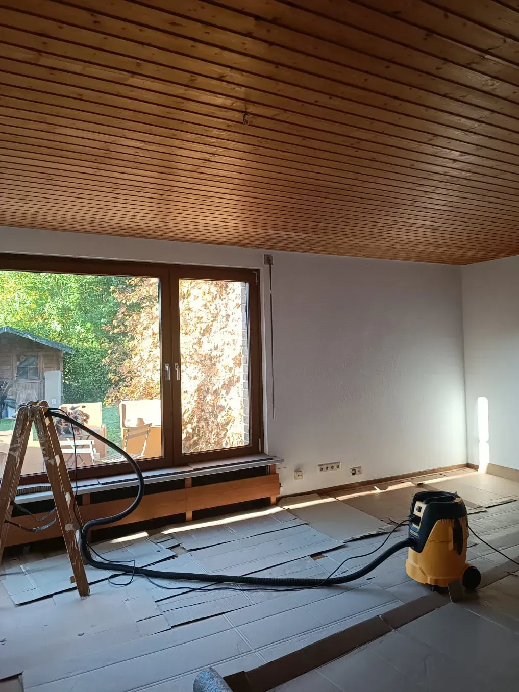 Ein Raum mit einem Staubsauger und einer Leiter darin.