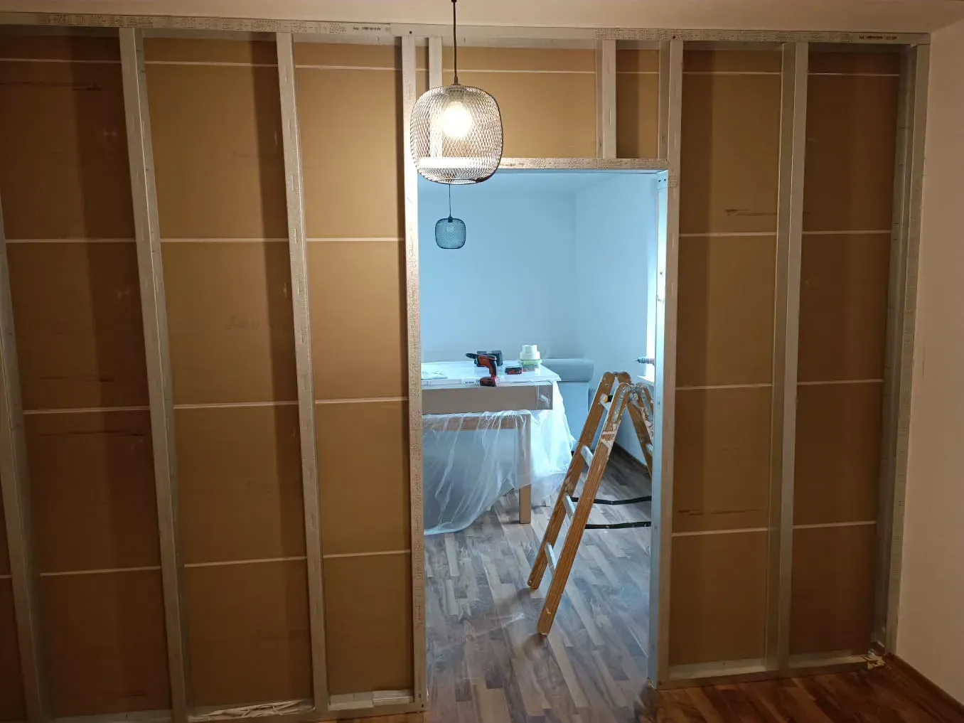 Ein Raum mit einer Leiter und einer Lampe, die von der Decke hängt.