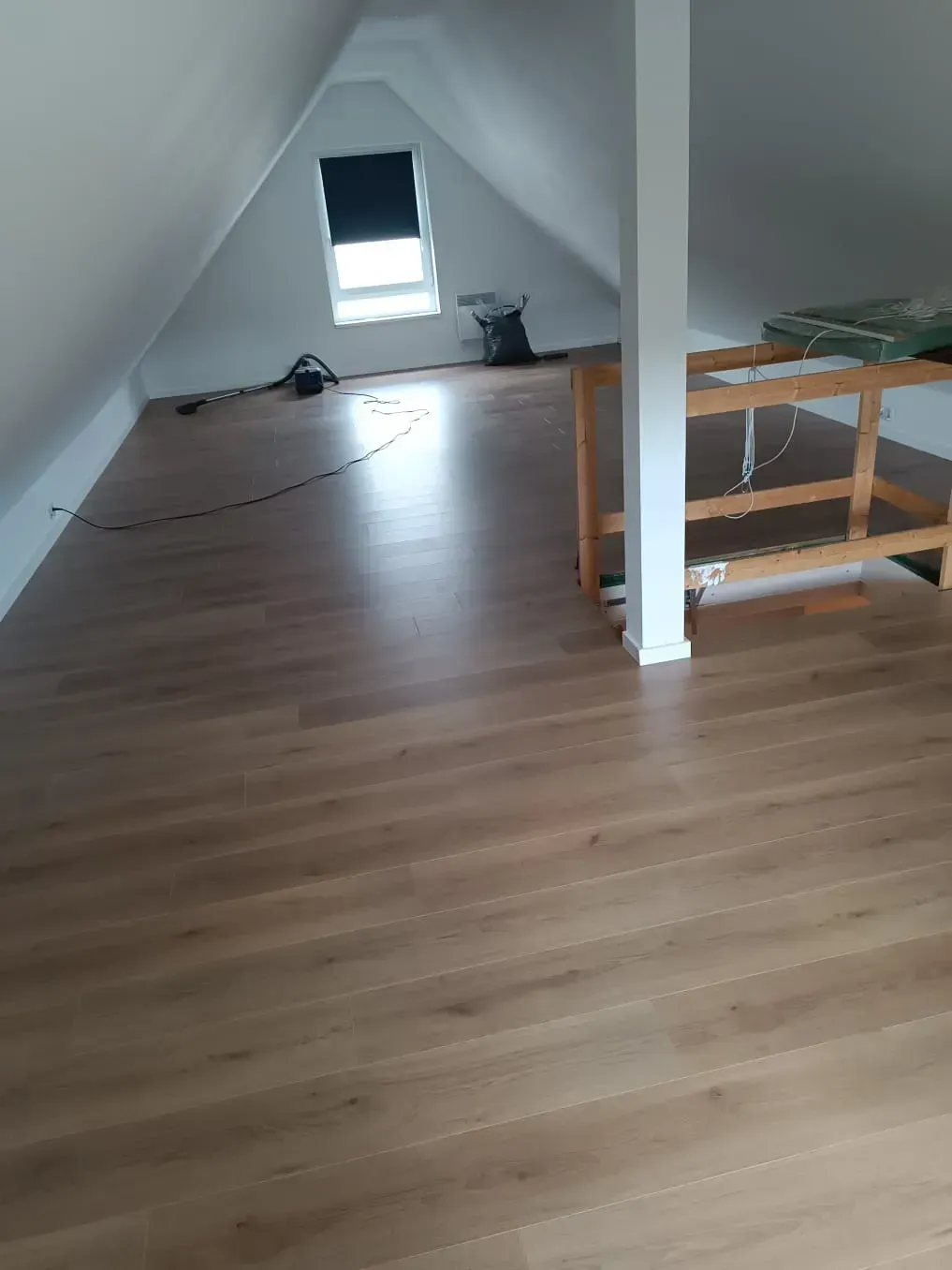 Ein Raum mit Holzboden und Fenster.