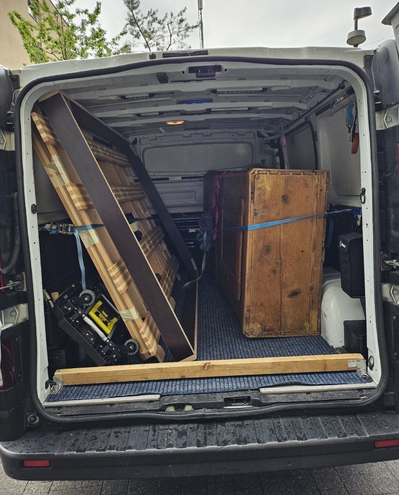 Die Rückseite eines Lieferwagens mit einem großen Stück Holz auf der Rückseite