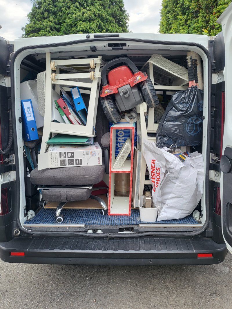 Der hintere Teil eines Lieferwagens ist mit viel Gerümpel vollgestopft.