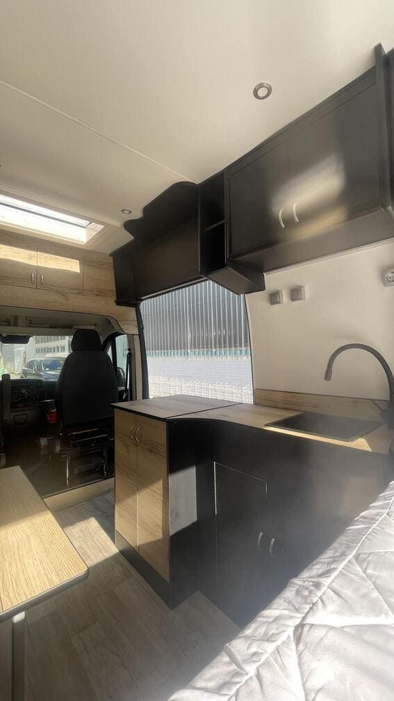 El interior de una furgoneta con cocina y fregadero.