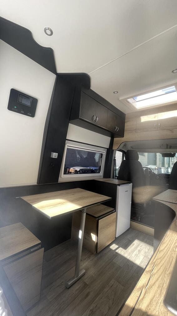 El interior de una furgoneta con una mesa y un televisor.