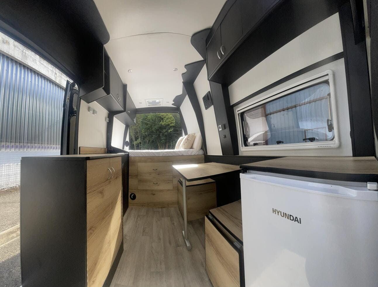 El interior de una furgoneta camper con un frigorífico Hyundai.